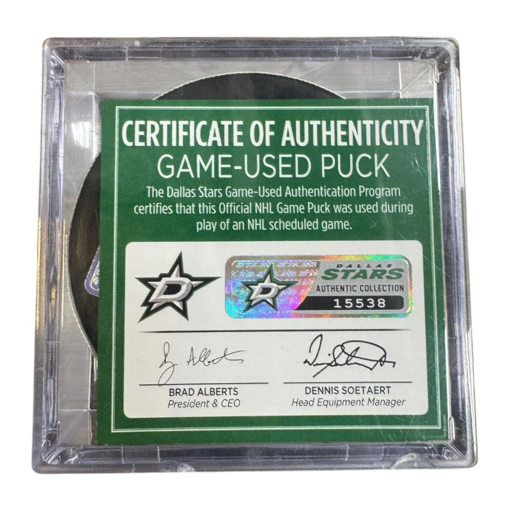 A game-used hockey puck in a clear plastic protective case with a green and white Certificate of Authenticity insert. COA #  15538

