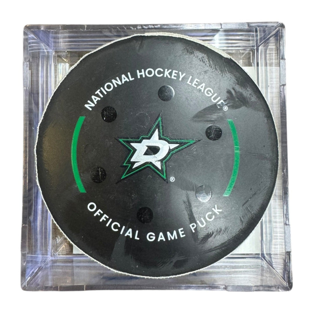 A Dallas Stars NHL official game/goal puck inside a clear plastic protective case, shown against a plain white background.
