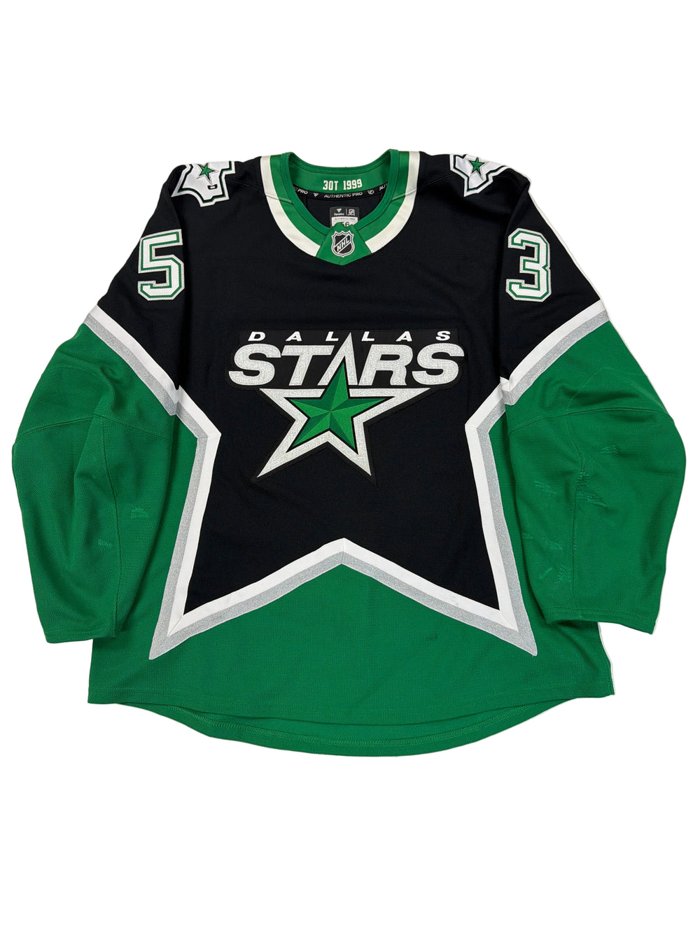 Green and black sports jersey with star logo on a white floor