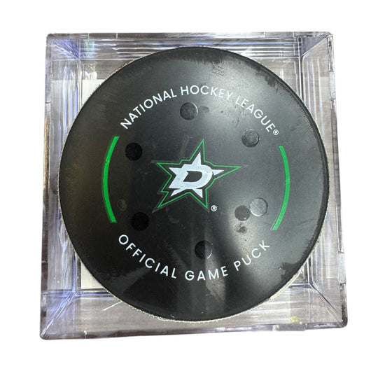 A Dallas Stars NHL official game/goal puck inside a clear plastic protective case, shown against a plain white background.