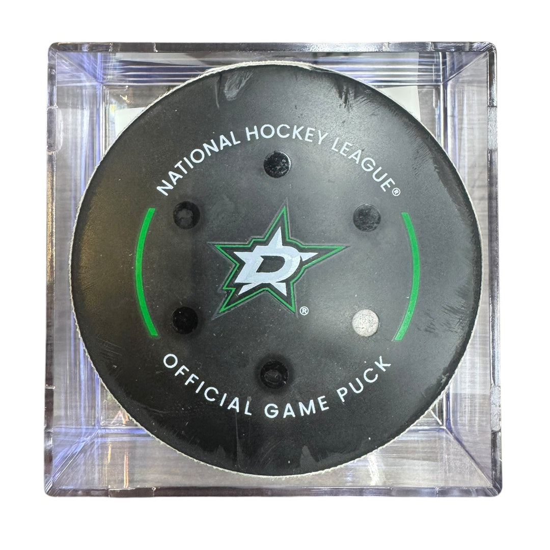 A Dallas Stars NHL official game/goal puck inside a clear plastic protective case, shown against a plain white background.