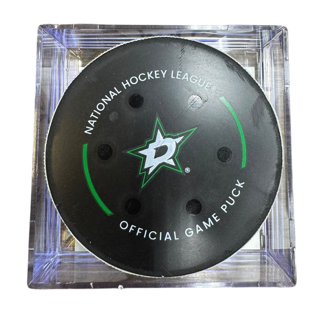 A Dallas Stars NHL official game/goal puck inside a clear plastic protective case, shown against a plain white background.
