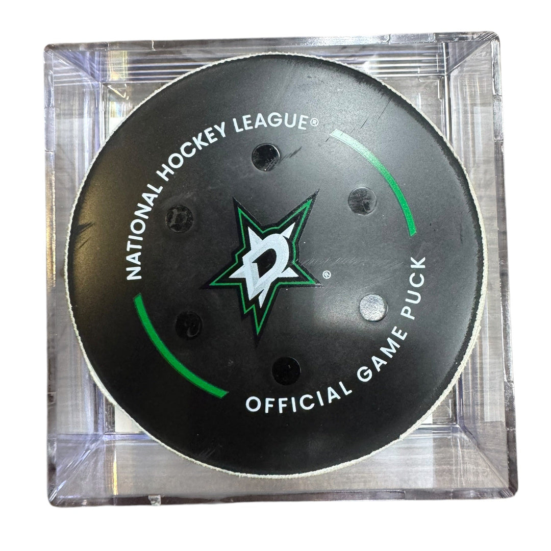 A Dallas Stars NHL official game/goal puck inside a clear plastic protective case, shown against a plain white background.
