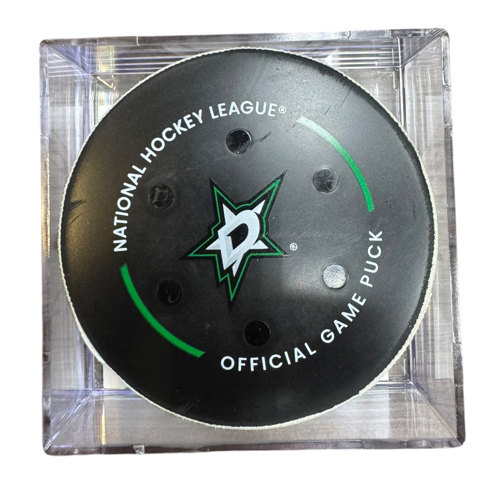 A Dallas Stars NHL official game/goal puck inside a clear plastic protective case, shown against a plain white background.