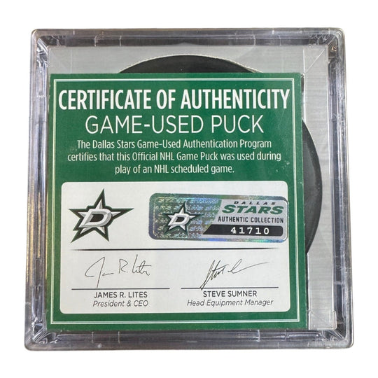 A game-used hockey puck in a clear plastic protective case with a green and white Certificate of Authenticity insert. 
COA 
