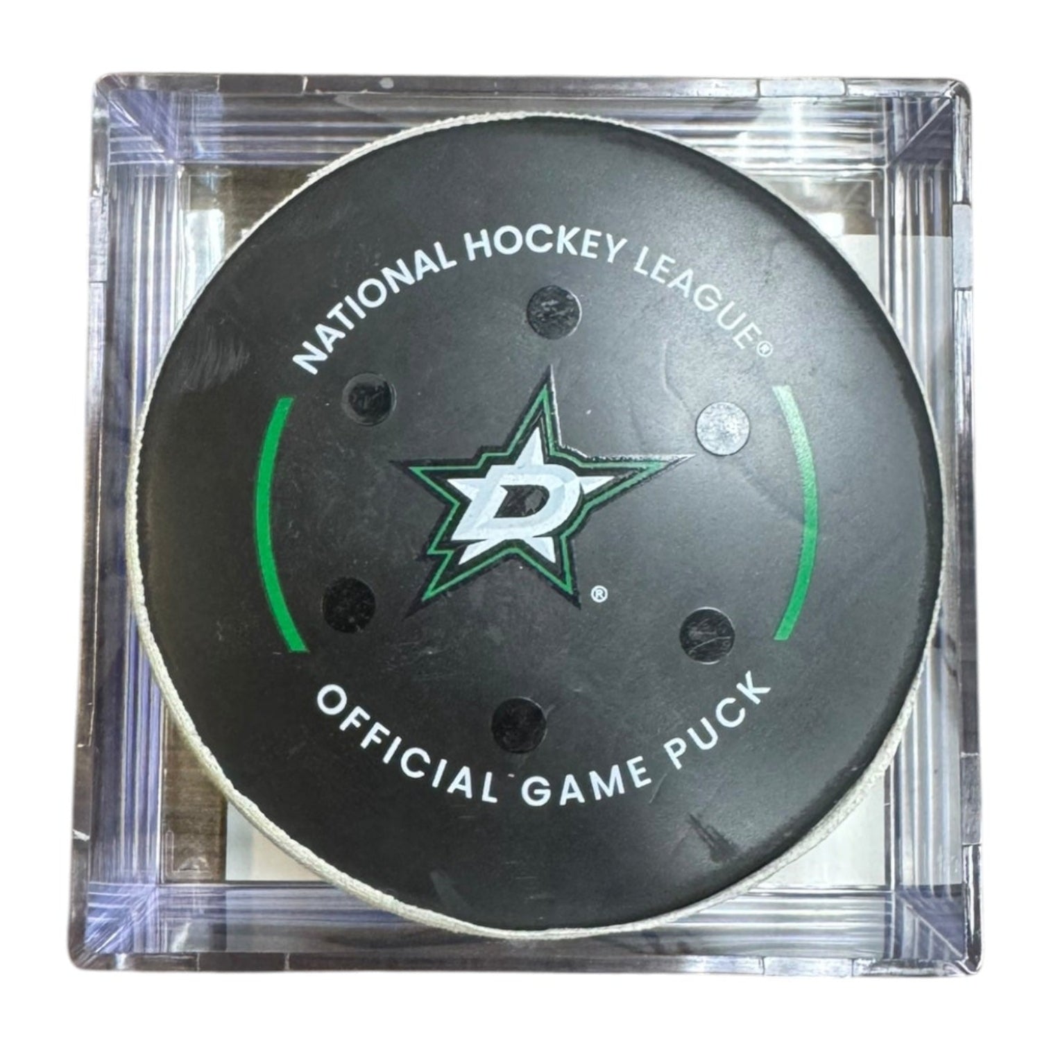 A Dallas Stars NHL official game/goal puck inside a clear plastic protective case, shown against a plain white background.