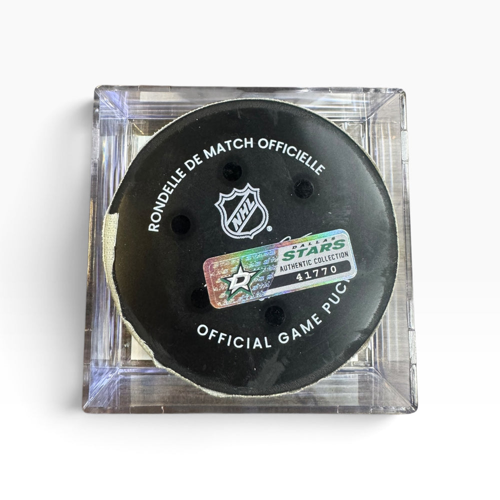 An NHL official game puck in a clear plastic protective case, featuring a black hockey puck with a holographic Stars Authentic Collector sticker.