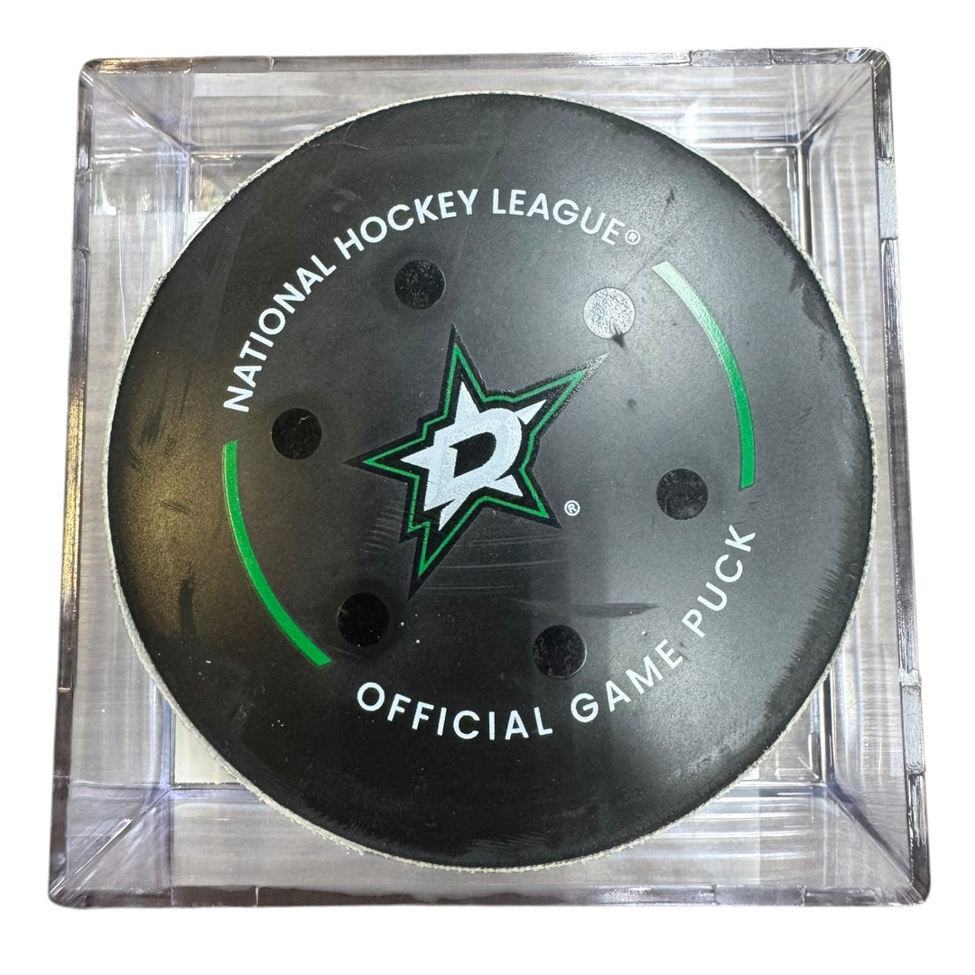 A Dallas Stars NHL official game/goal puck inside a clear plastic protective case, shown against a plain white background.