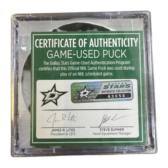 A game-used hockey puck in a clear plastic protective case with a green and white Certificate of Authenticity insert. 
COA 
