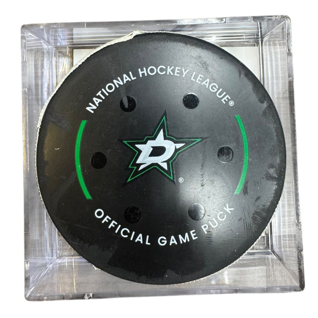 A Dallas Stars NHL official game/goal puck inside a clear plastic protective case, shown against a plain white background.