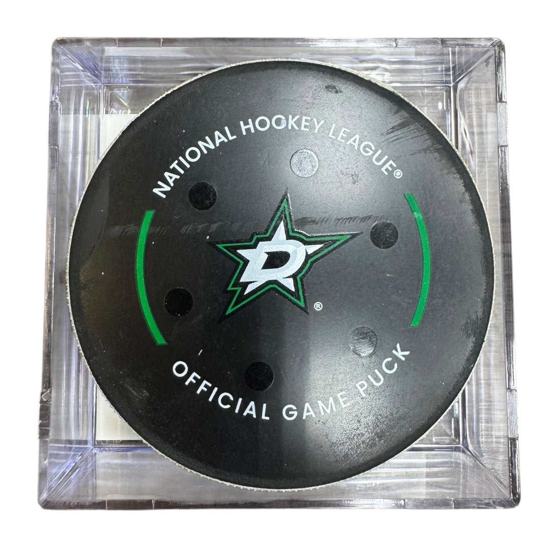 A Dallas Stars NHL official game/goal puck inside a clear plastic protective case, shown against a plain white background.