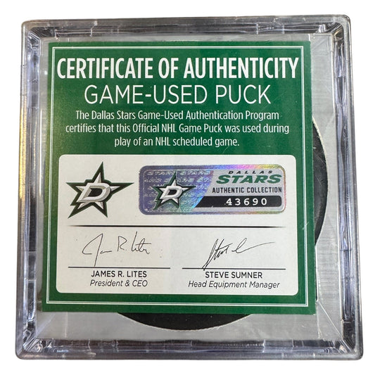 A game-used hockey puck in a clear plastic protective case with a green and white Certificate of Authenticity insert. 
COA 