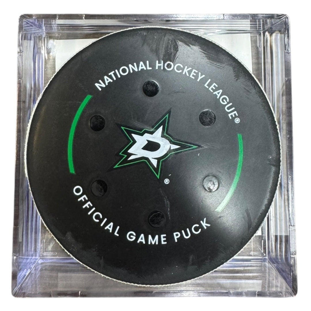 A Dallas Stars NHL official game/goal puck inside a clear plastic protective case, shown against a plain white background.