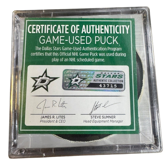 A game-used hockey puck in a clear plastic protective case with a green and white Certificate of Authenticity insert. 
COA 