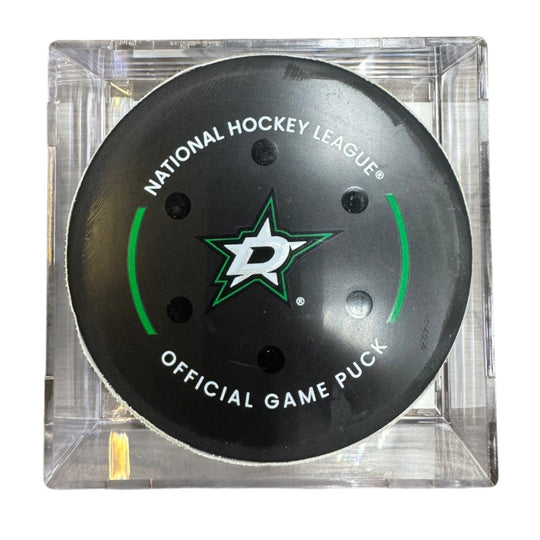 A Dallas Stars NHL official game/goal puck inside a clear plastic protective case, shown against a plain white background.