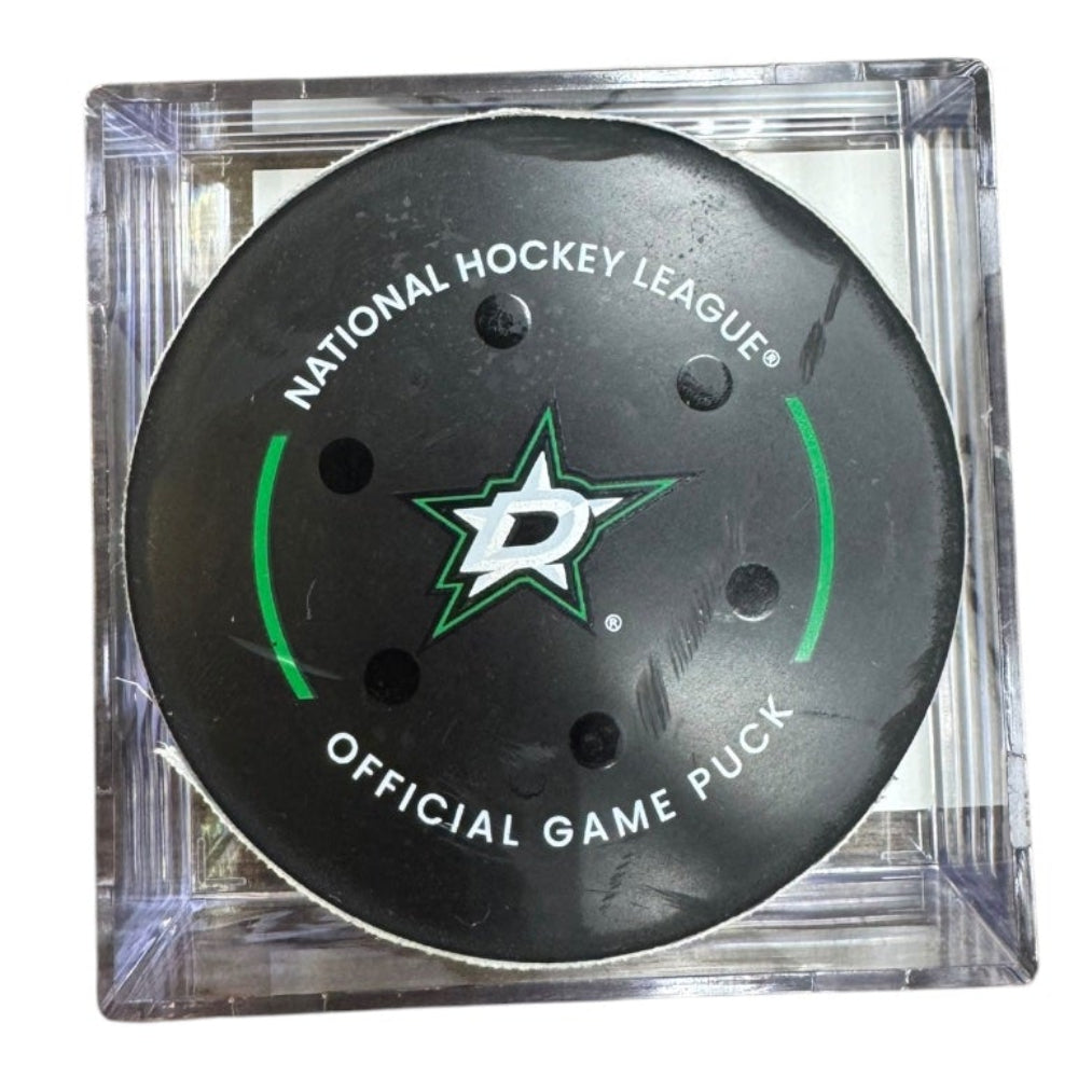 A Dallas Stars NHL official game/goal puck inside a clear plastic protective case, shown against a plain white background.