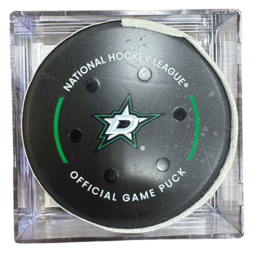 A Dallas Stars NHL official game/goal puck inside a clear plastic protective case, shown against a plain white background.