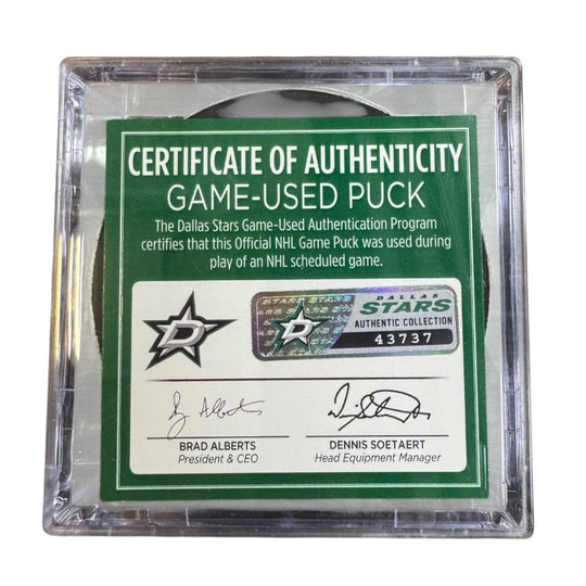 A game-used hockey puck in a clear plastic protective case with a green and white Certificate of Authenticity insert. 
COA 