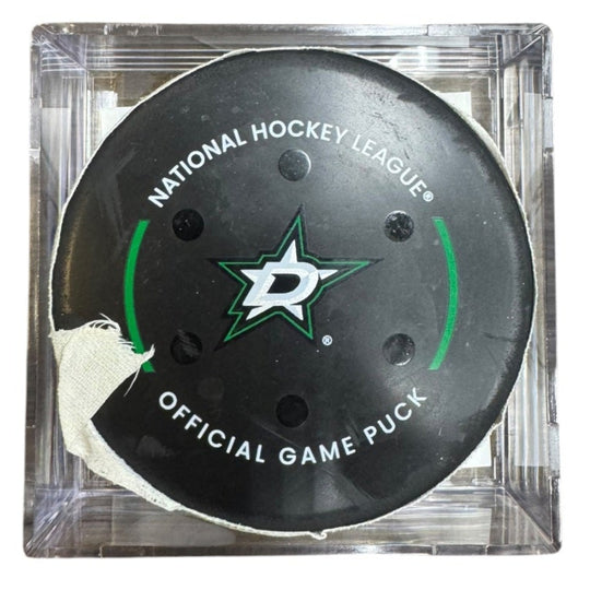 A Dallas Stars NHL official game/goal puck inside a clear plastic protective case, shown against a plain white background.