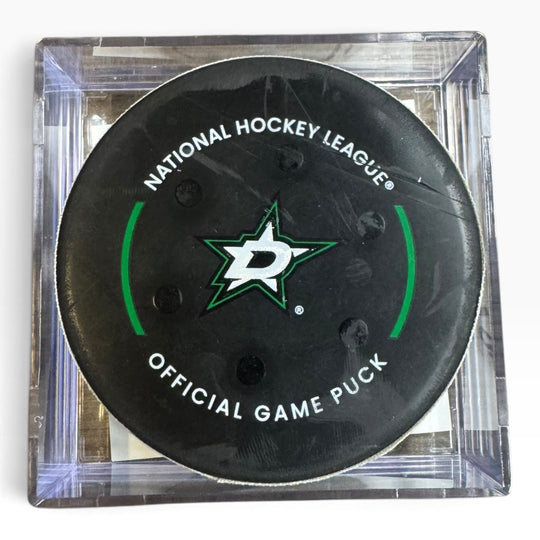 A Dallas Stars National Hockey League official game puck displayed inside a clear plastic square case on a white background.