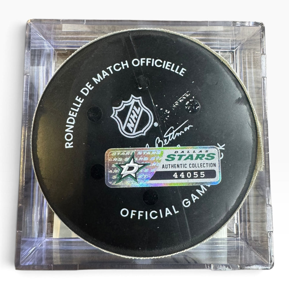 A NHL official hockey puck displayed inside a clear acrylic case, featuring a Dallas Stars authentic collection sticker.