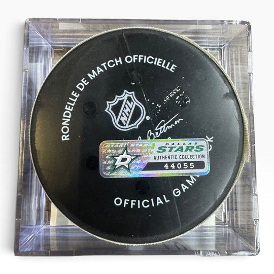 A NHL official hockey puck displayed inside a clear acrylic case, featuring a Dallas Stars authentic collection sticker.