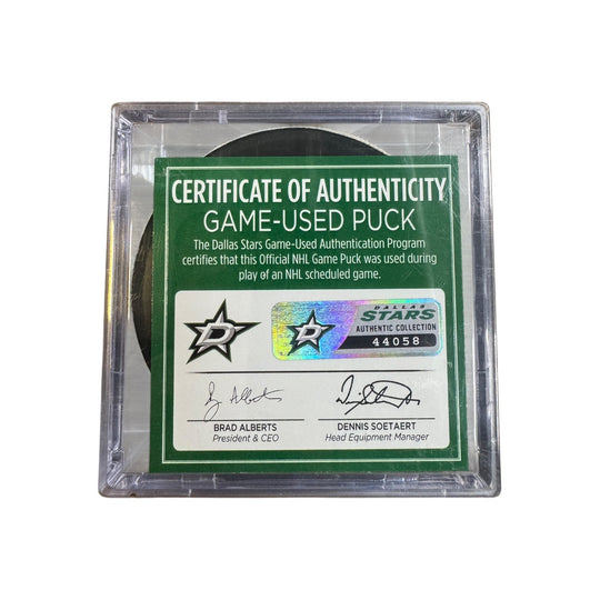 A game-used hockey puck in a clear plastic protective case with a green and white Certificate of Authenticity insert. 

COA 
