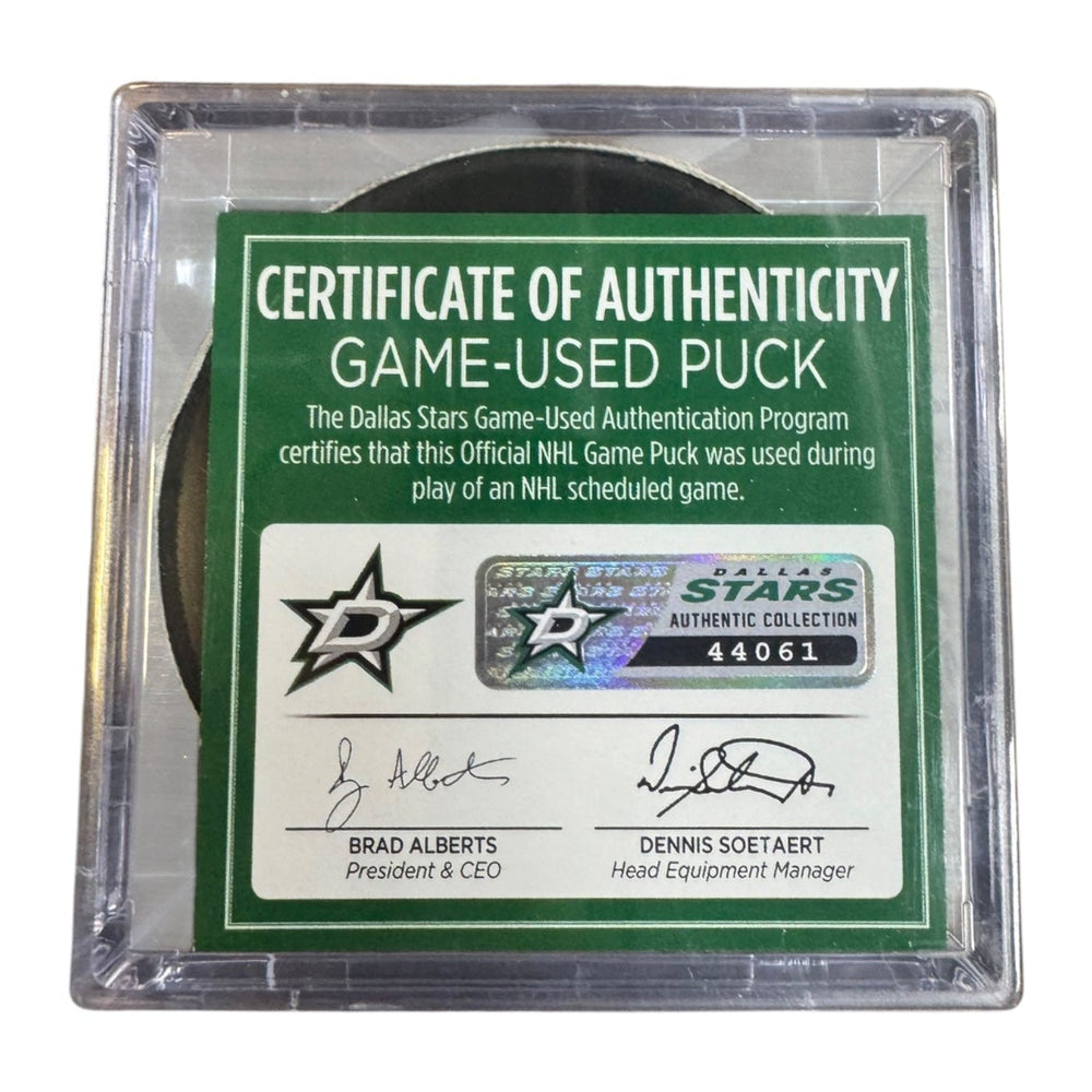 A game-used hockey puck in a clear plastic protective case with a green and white Certificate of Authenticity insert.  
COA # 44061