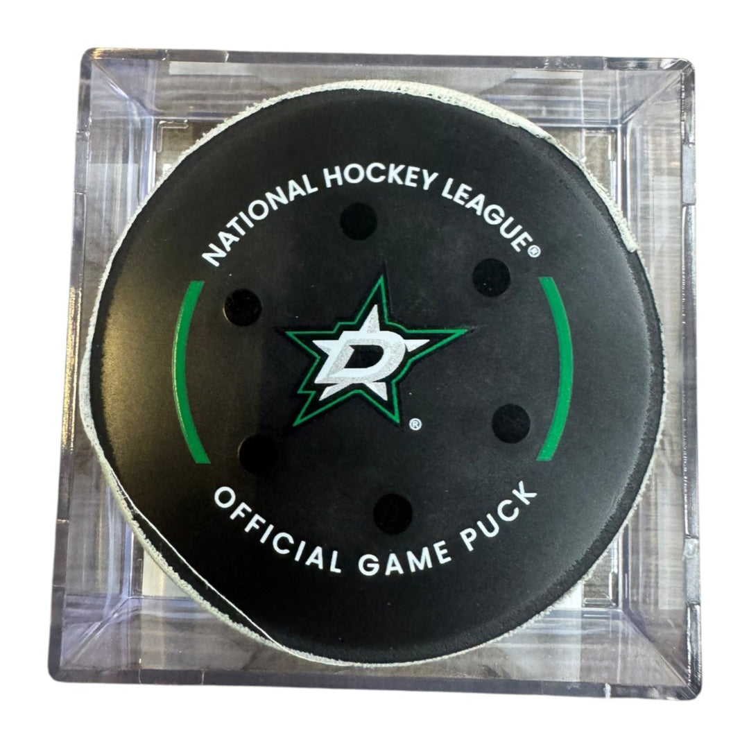 A Dallas Stars NHL official game/goal puck inside a clear plastic protective case, shown against a plain white background.