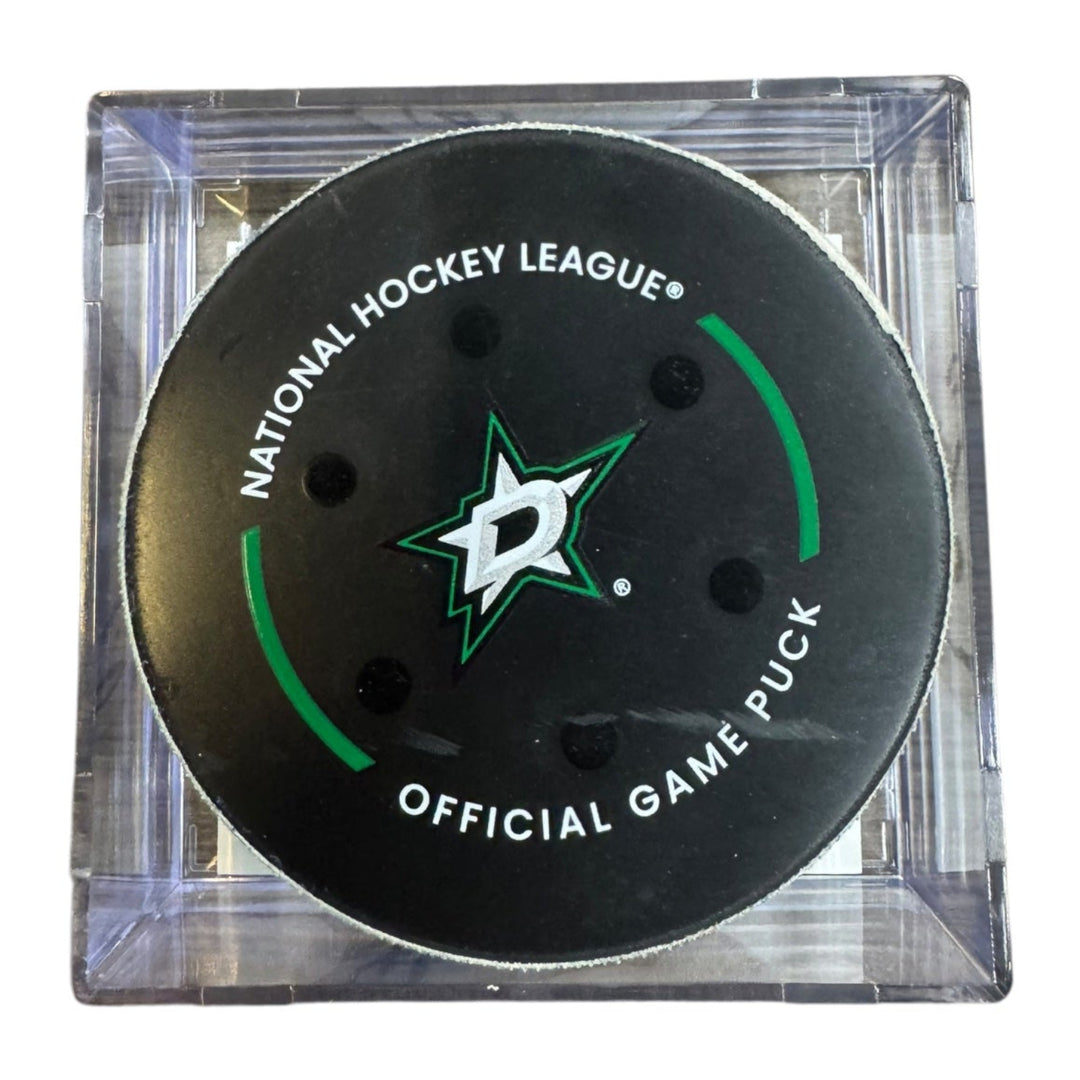 A Dallas Stars NHL official game/goal puck inside a clear plastic protective case, shown against a plain white background.
