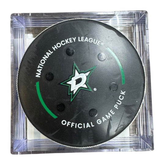 A Dallas Stars NHL official game/goal puck inside a clear plastic protective case, shown against a plain white background.
