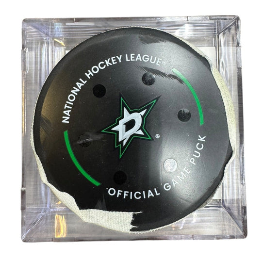 A Dallas Stars NHL official game/goal puck inside a clear plastic protective case, shown against a plain white background.
