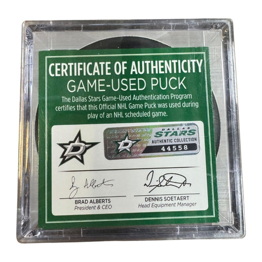 A game-used hockey puck in a clear plastic protective case with a green and white Certificate of Authenticity insert. 
COA 