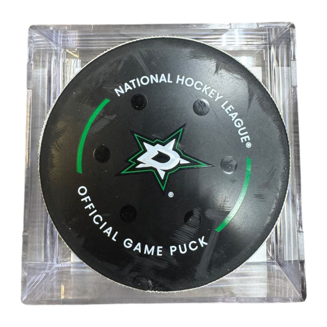 A Dallas Stars NHL official game/goal puck inside a clear plastic protective case, shown against a plain white background.