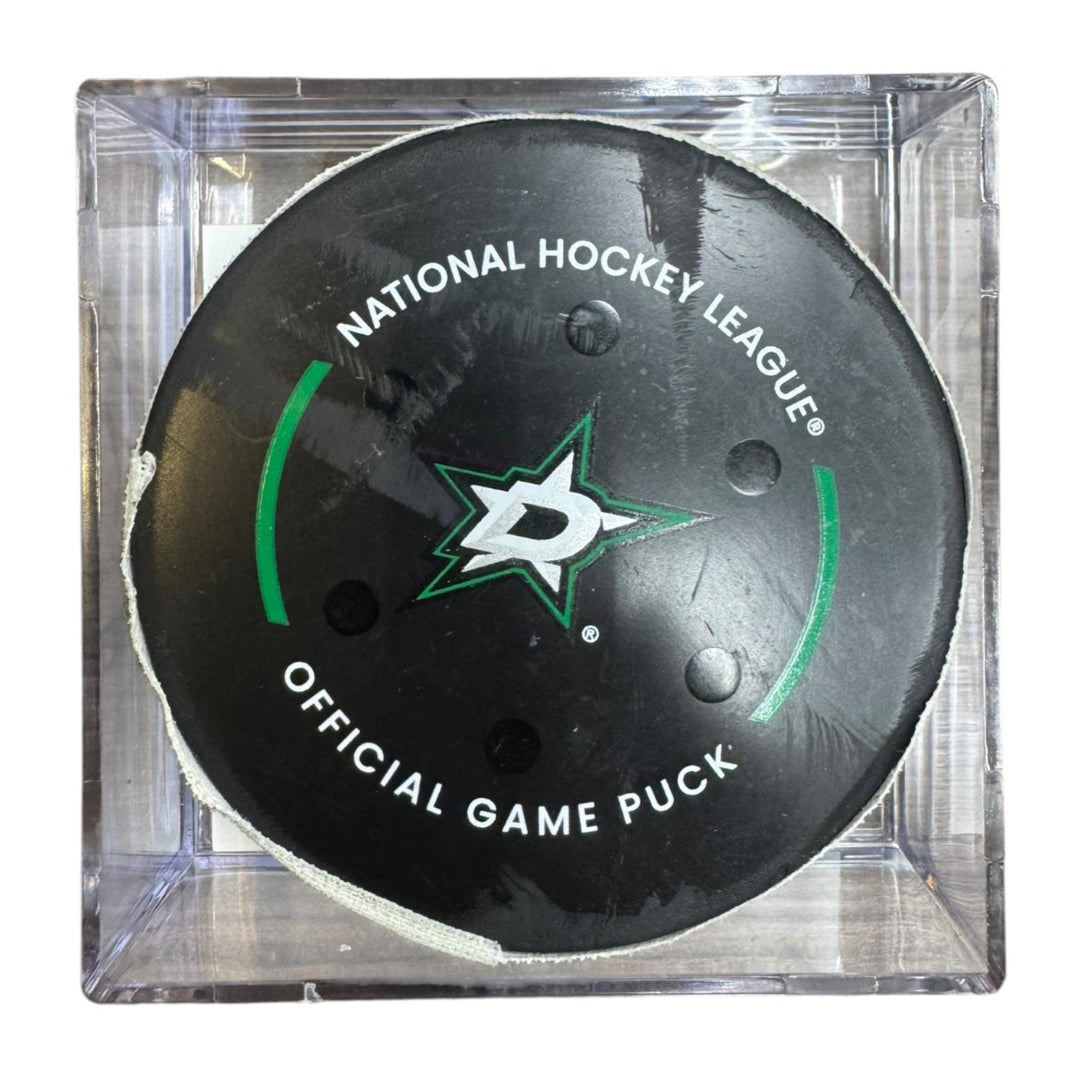A Dallas Stars NHL official game/goal puck inside a clear plastic protective case, shown against a plain white background.