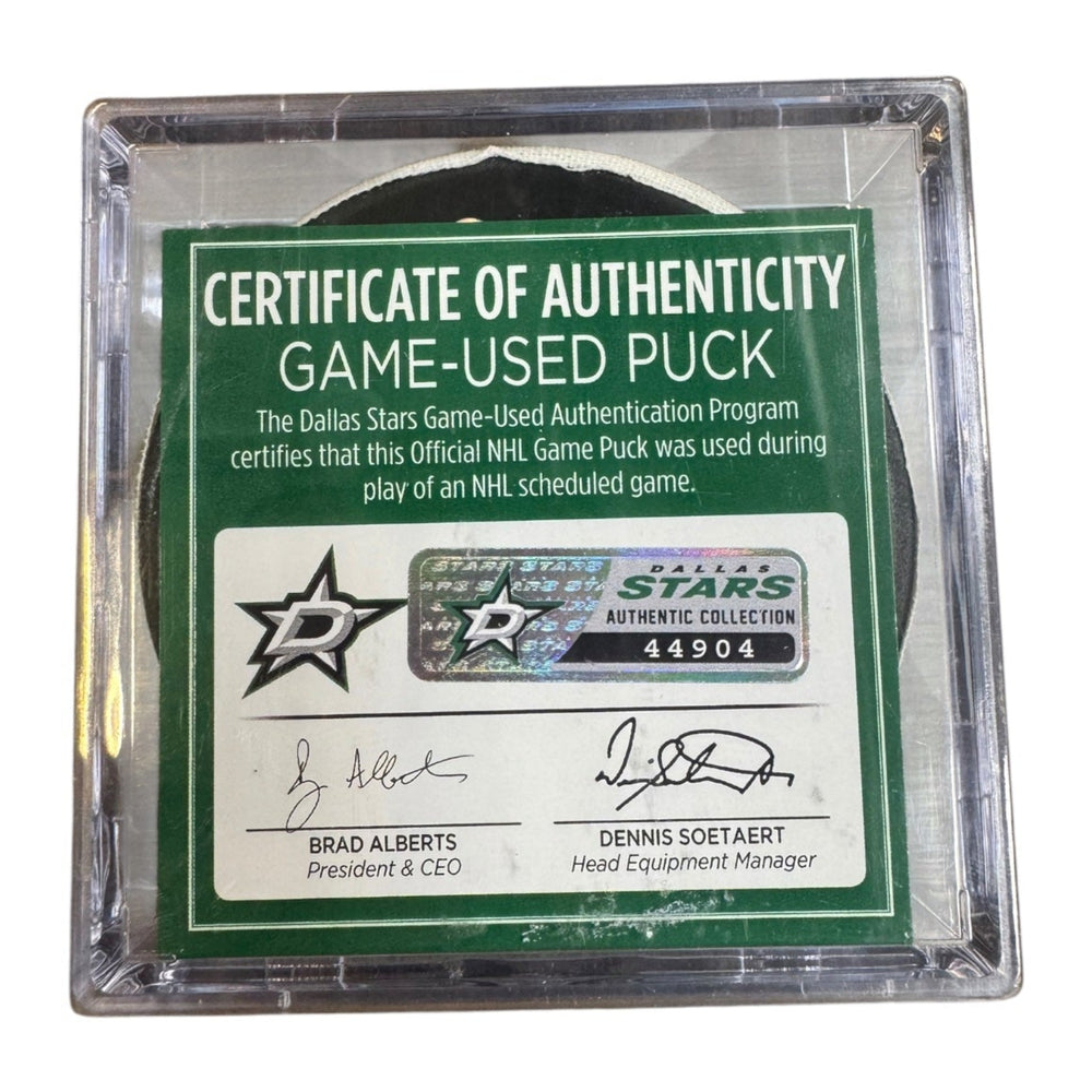 A game-used hockey puck in a clear plastic protective case with a green and white Certificate of Authenticity insert. COA #  44904
