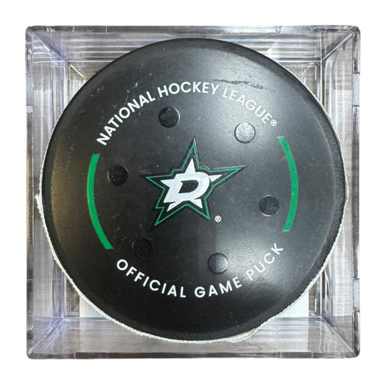 A Dallas Stars NHL official game/goal puck inside a clear plastic protective case, shown against a plain white background.
