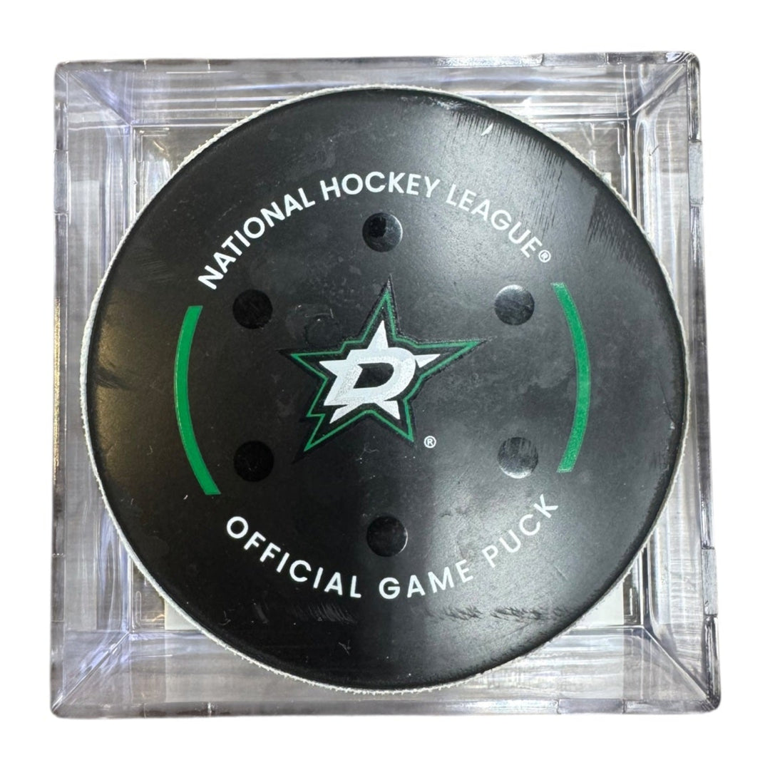 A Dallas Stars NHL official game/goal puck inside a clear plastic protective case, shown against a plain white background.

