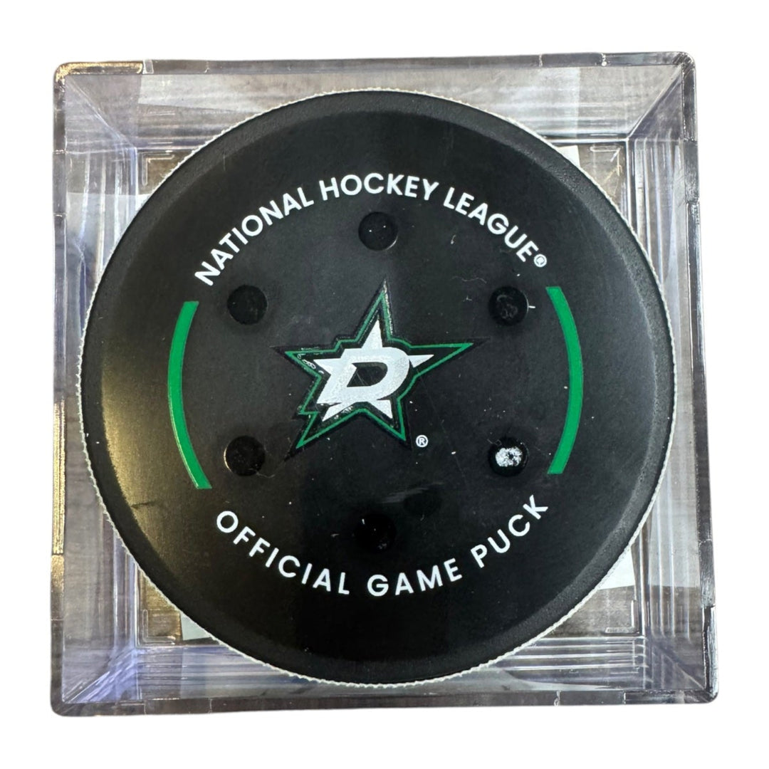 A Dallas Stars NHL official game/goal puck inside a clear plastic protective case, shown against a plain white background.