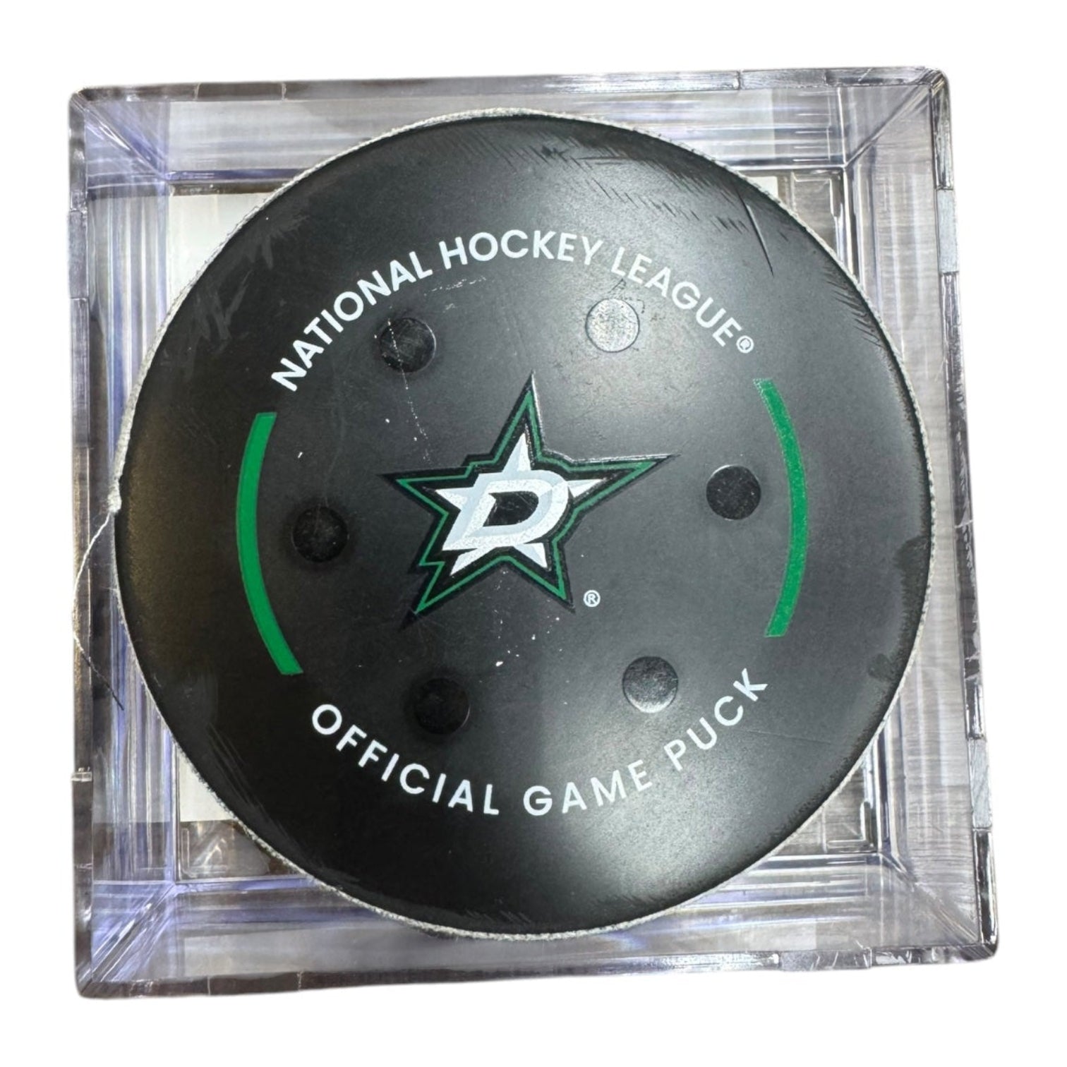A Dallas Stars NHL official game/goal puck inside a clear plastic protective case, shown against a plain white background.
