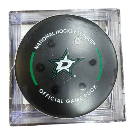 A Dallas Stars NHL official game/goal puck inside a clear plastic protective case, shown against a plain white background.
