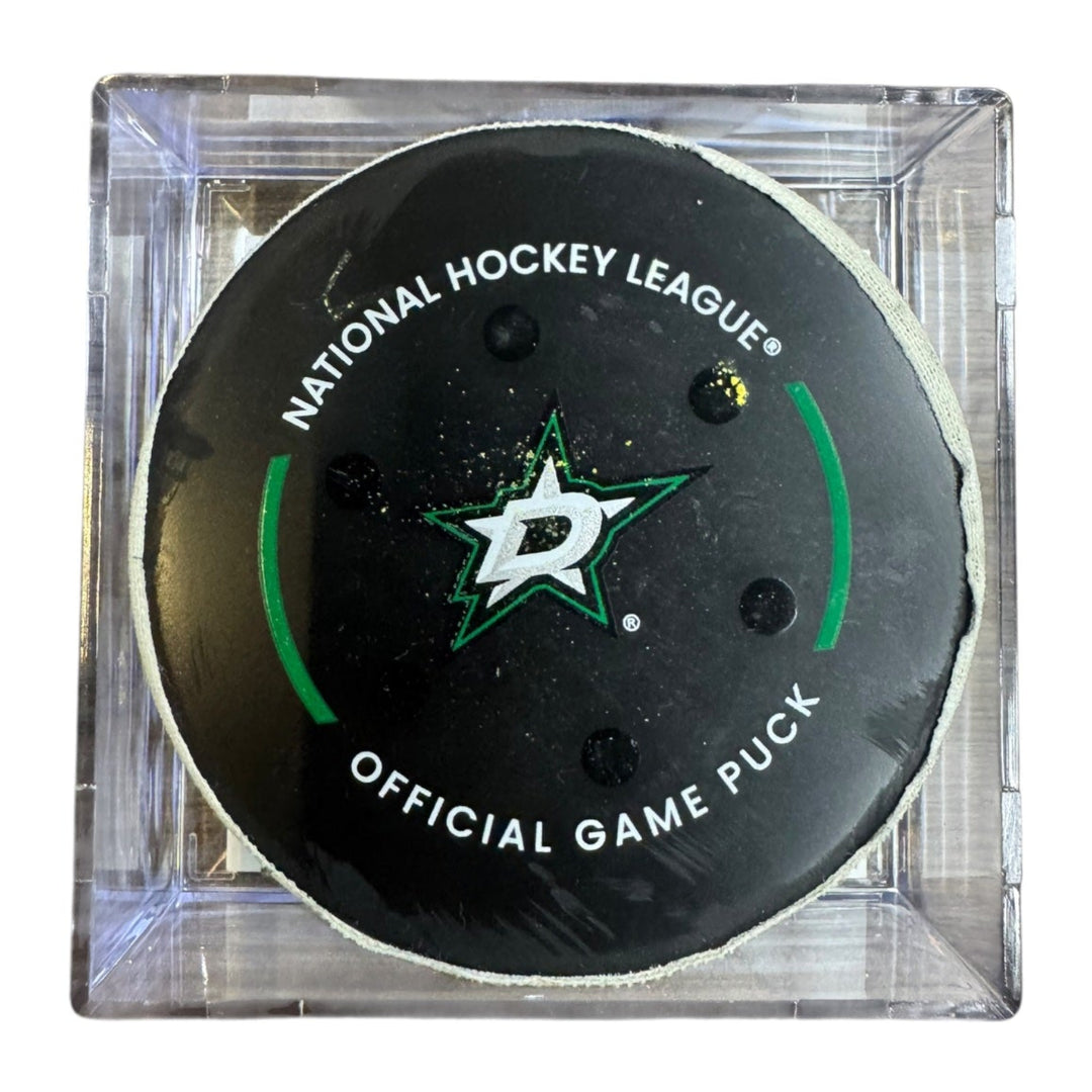 A Dallas Stars NHL official game/goal puck inside a clear plastic protective case, shown against a plain white background.