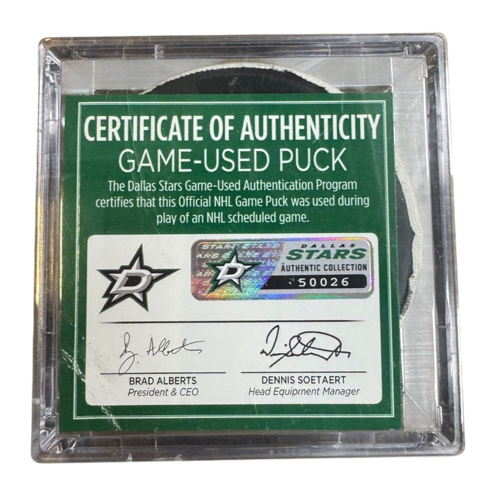A game-used hockey puck in a clear plastic protective case with a green and white Certificate of Authenticity insert. COA #  50026

