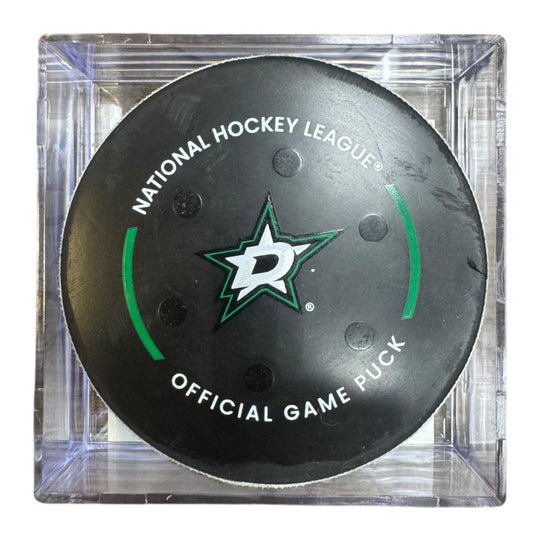 A Dallas Stars NHL official game/goal puck inside a clear plastic protective case, shown against a plain white background.
