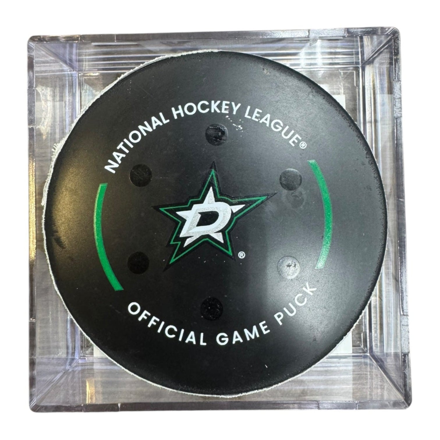 A Dallas Stars NHL official game/goal puck inside a clear plastic protective case, shown against a plain white background.
