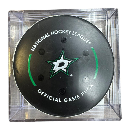 A Dallas Stars NHL official game/goal puck inside a clear plastic protective case, shown against a plain white background.
