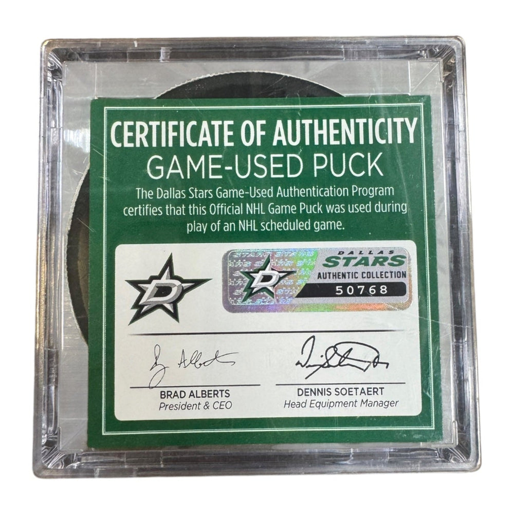 A game-used hockey puck in a clear plastic protective case with a green and white Certificate of Authenticity insert. COA #  50768
