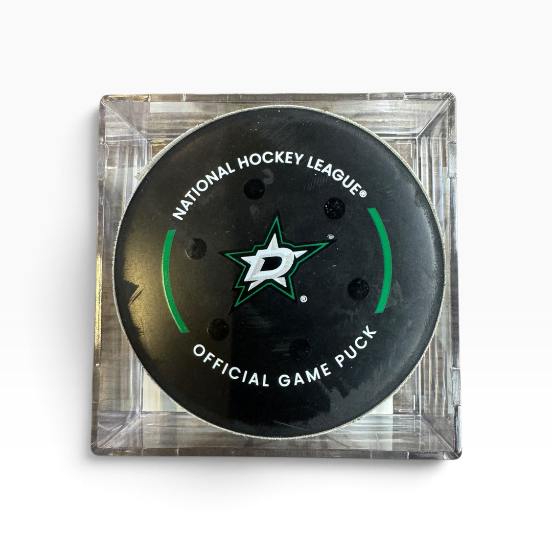 Dallas Stars National Hockey League official game puck in a clear square plastic case, photographed on a white background.