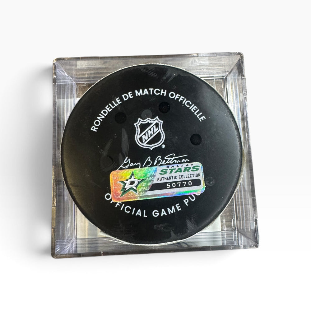 Official NHL game puck displayed inside a clear acrylic block on a white background. The puck features the NHL shield logo, a signature, and a holographic Stars Authentic Collection sticker.