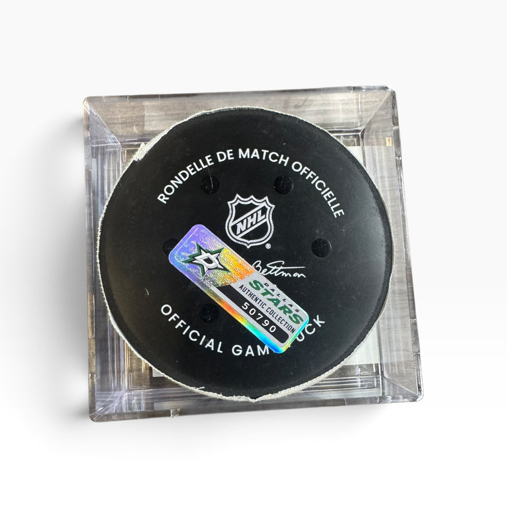 An official NHL hockey puck displayed inside a clear acrylic block, featuring the black puck with white text and a holographic Stars autograph sticker.